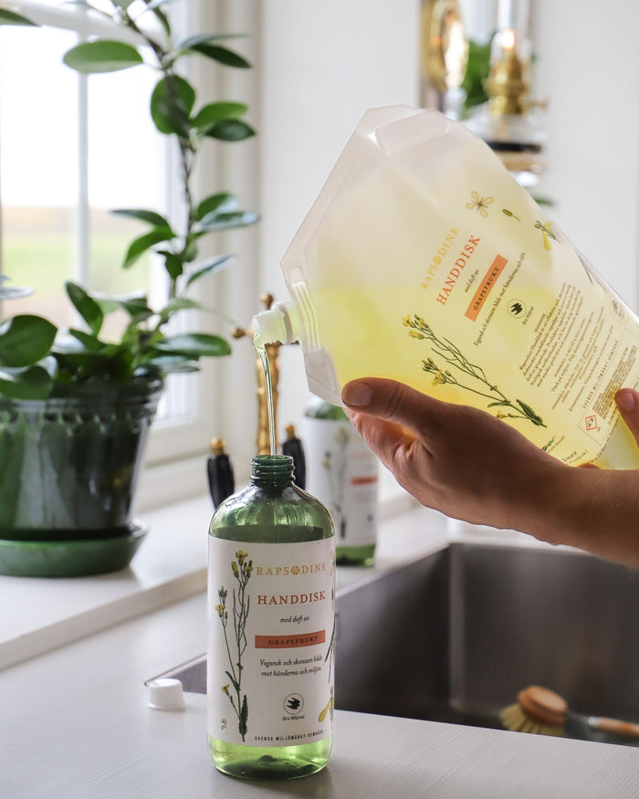 Rapsodines handdisk med refillfรถrpackning i naturlig kรถksmiljรถ med fokus pรฅ hรฅllbar pรฅfyllning
