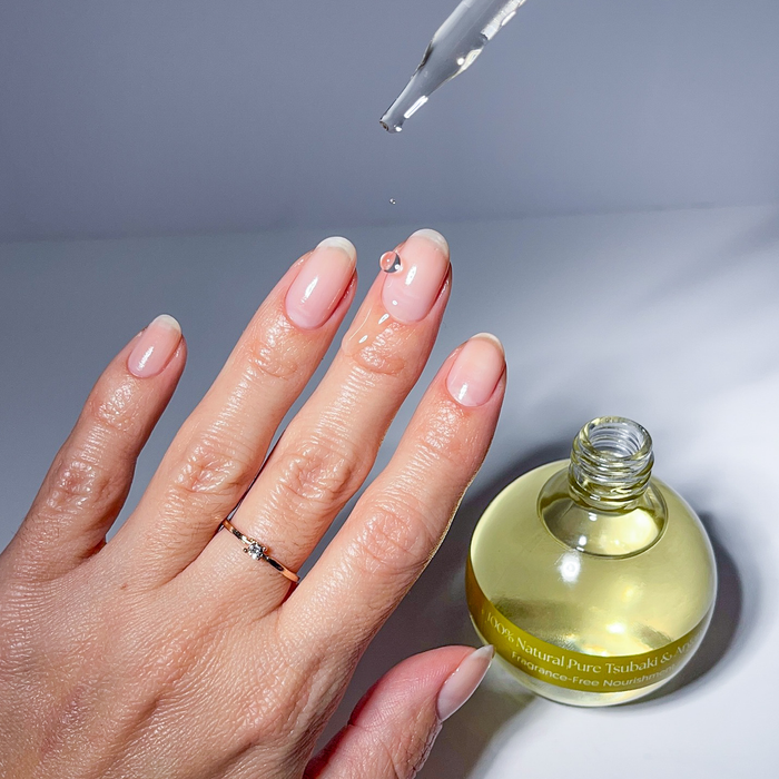 Applying Tsubaki & Argan cuticle oil with the dropper to a nude manicure