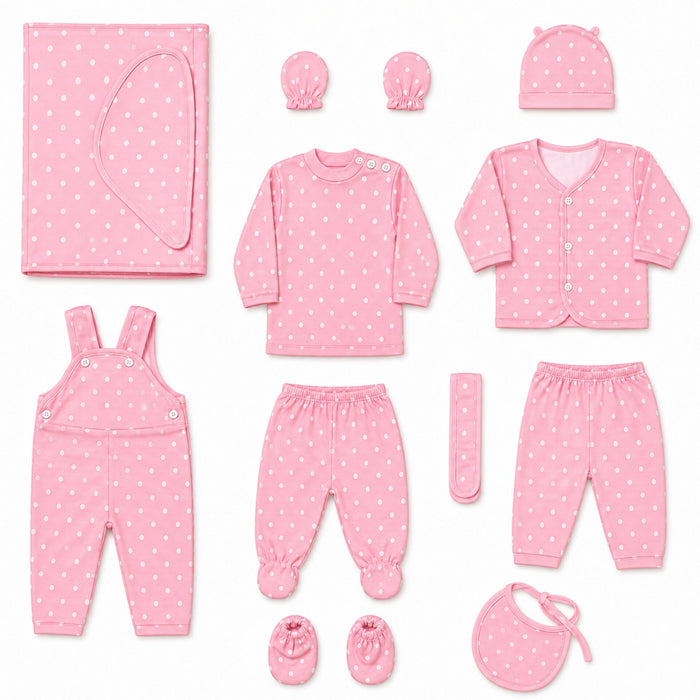 A baby clothing set arranged on a white background, including a pink long-sleeve top, matching pants, cardigan, overalls, booties, bib, hat, swaddle, and a small remote control, all in a light pink fabric with small white polka dots.