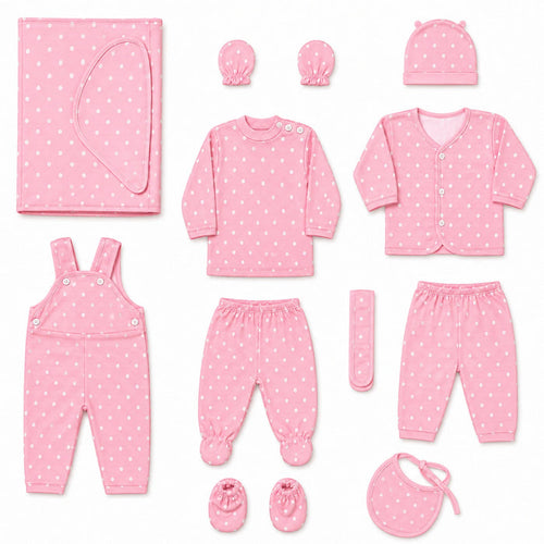 A baby clothing set arranged on a white background, including a pink long-sleeve top, matching pants, cardigan, overalls, booties, bib, hat, swaddle, and a small remote control, all in a light pink fabric with small white polka dots.