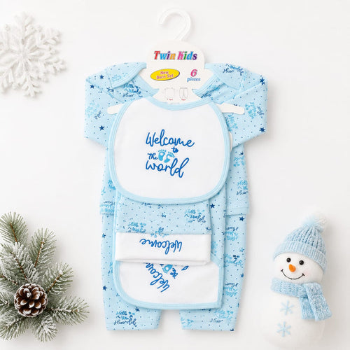 A twin baby onesie and bib set in light blue with a snowflake pattern, displayed on a white background with holiday props including a snowman decoration, pine branch, and snowflake ornament. The packaging card at the top reads 'Twin Kids'.