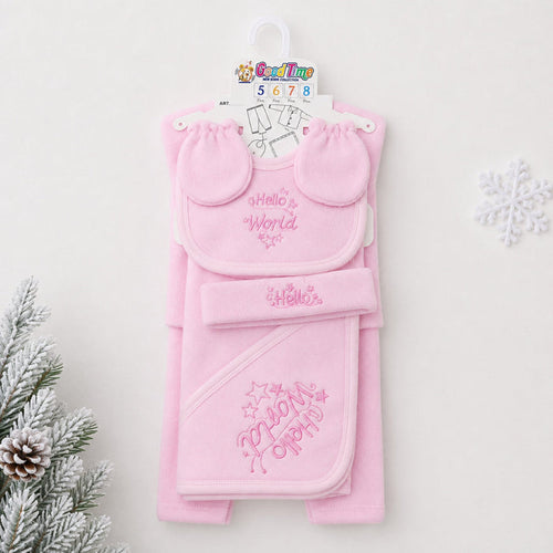 A pink baby gift set hanging on a white hanger against a light background, featuring a bib with 'Hello World' embroidery, a matching hat, and a hooded towel with 'My First Party' embroidery. Decorative pine branches and a snowflake are visible at the edge