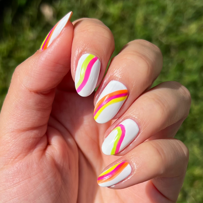 Atomic Orange and neon liners used for rainbow swirl nail art on white nails