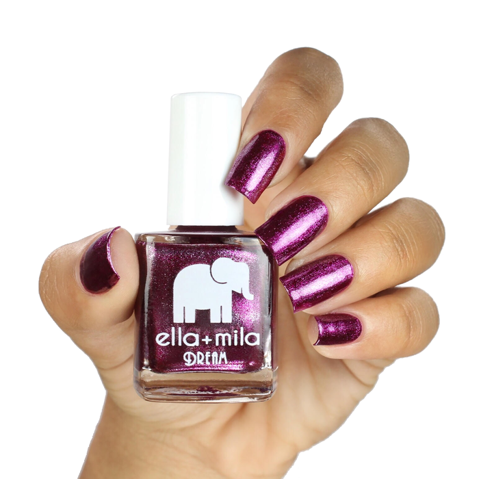 Bang Bang metallic purple-pink nail polish on a medium skin tone, hand holding the bottle