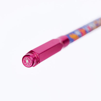 A close-up of a pink pencil point guard, featuring a white flower emblem, on a clean white background.