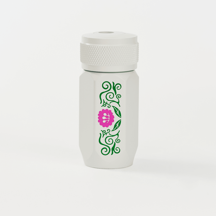 A white Blackwing one-step sharpener  featuring a green vine pattern and a pink flower graphic on the side.