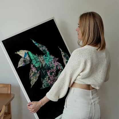 Woman holding a large "Botanical 4 Black Print" with layered green and purple leaves on a black background.