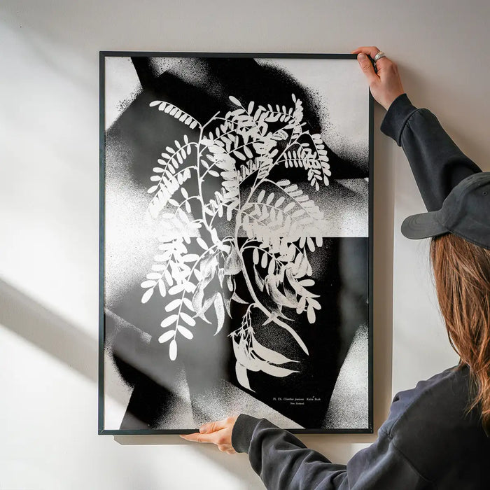 Black and white botanical floral spray print on archival art paper, held by hands.