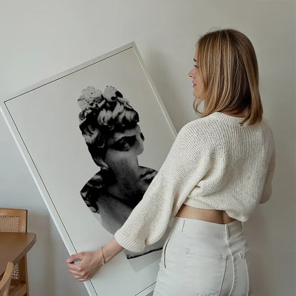 Woman holding a large black and white graphic print of a classic Roman bust on archival art paper.