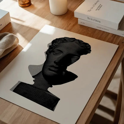 Black and white graphic print of a classic Roman bust on archival art paper, displayed on a wooden table.