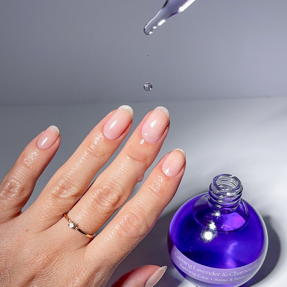 Applying Lavender & Chamomile cuticle oil with the dropper to a nude manicure