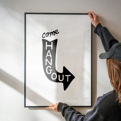Black framed "Come Hang Out" typographic print with a downward arrow design on white archival art paper.