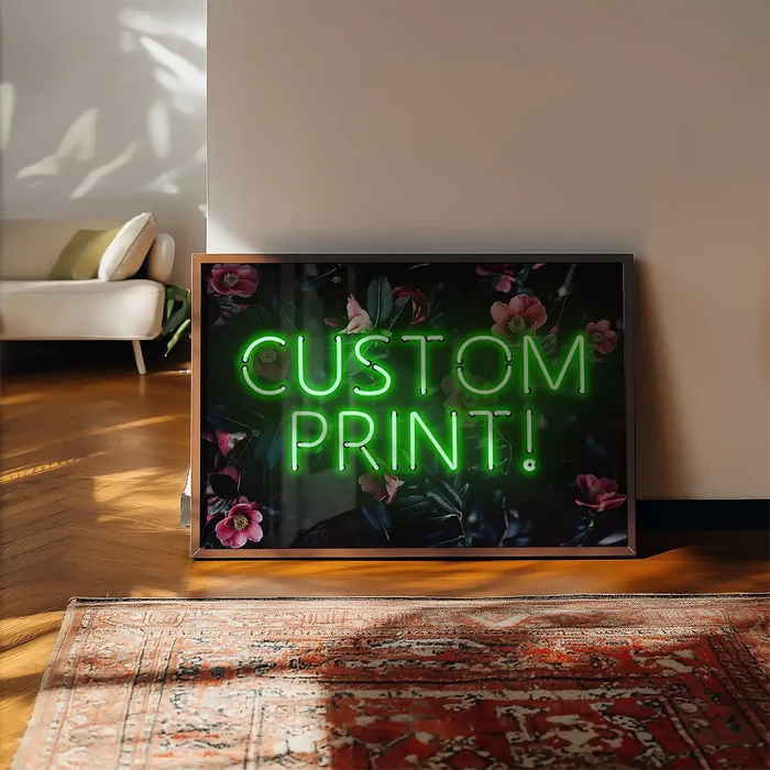 Custom green neon style print with "CUSTOM PRINT!" text on a dark floral background, framed, leaning against a wall.