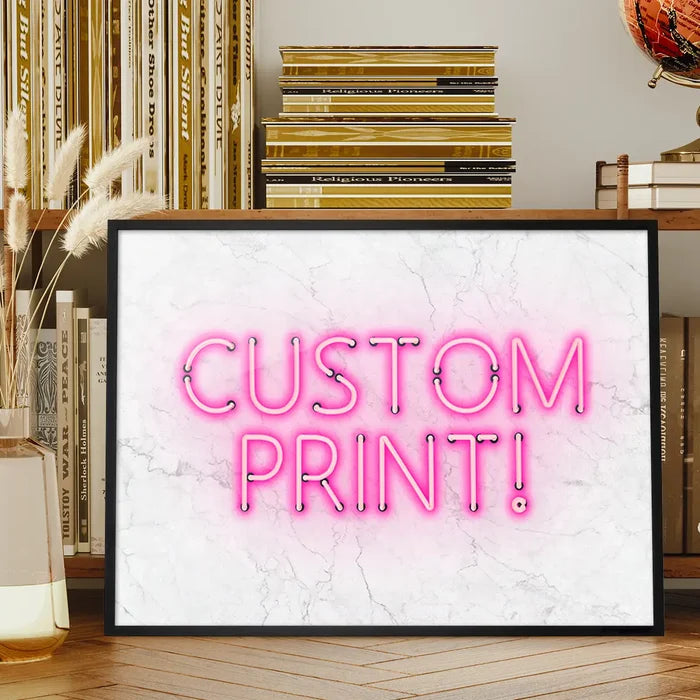 Framed custom art print with "CUSTOM PRINT!" in glowing pink neon text on a white marble background.