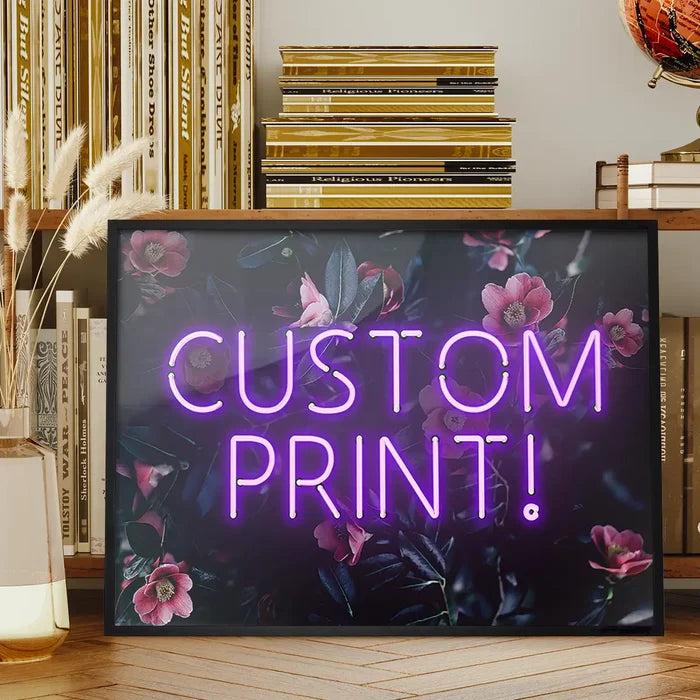Custom purple neon text "CUSTOM PRINT!" on a dark floral background print, framed on a wooden surface.