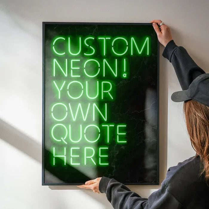 Person holding a framed custom green neon sign print with "CUSTOM NEON! YOUR OWN QUOTE HERE" text.