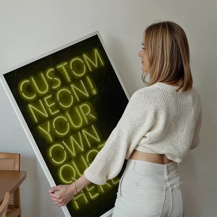 Woman holding a large framed custom yellow neon sign print with "CUSTOM NEON! YOUR OWN QUOTE HERE" text.