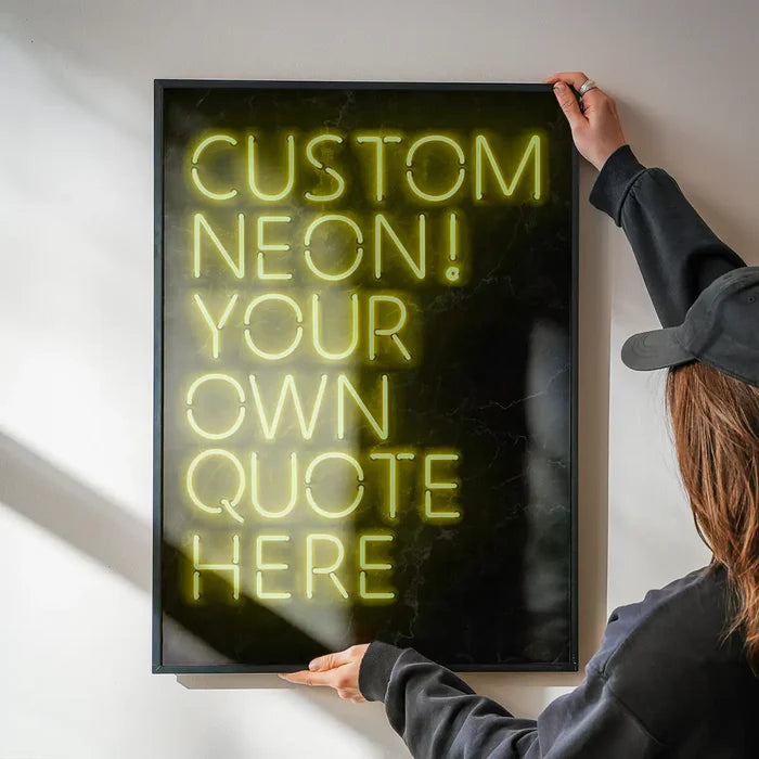 Person holding a framed custom yellow neon sign print with "CUSTOM NEON! YOUR OWN QUOTE HERE" text.
