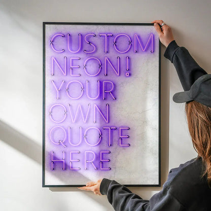 Person hanging a framed custom purple neon print with "CUSTOM NEON! YOUR OWN QUOTE HERE" text.