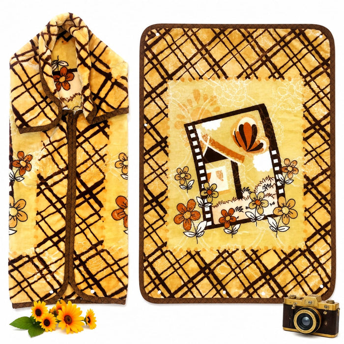A yellow fleece blanket with a brown plaid pattern and a central floral house design, shown folded on the left and laid flat on the right. The blanket features a warm yellow base with brown grid lines, orange flowers, and a small house illustration in the