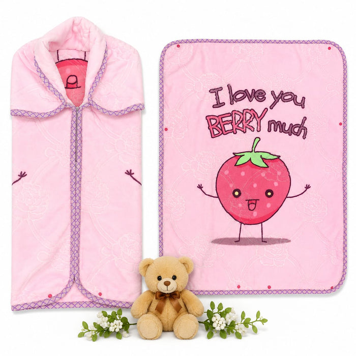 A pink baby blanket and matching pink swaddle wrap set, displayed on a white background with a small teddy bear and white flowers as props. The blanket features a cute cartoon strawberry character and the text 'I love you BERRY much'.