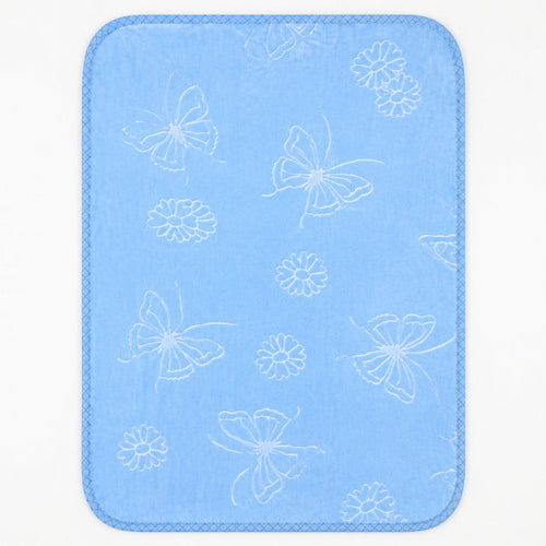 A rectangular baby blanket with rounded corners, featuring a light blue textured fabric with a white pattern of butterflies, flowers, and leaves, finished with a stitched border.