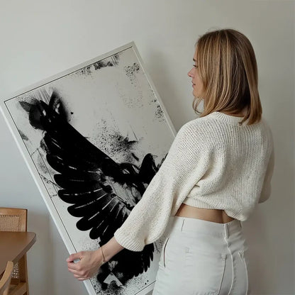 Woman holding a framed black and white abstract Dove graffiti print on thick art paper.
