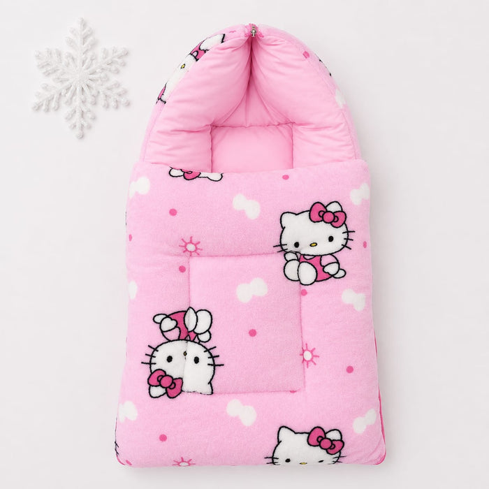 A pink quilted baby footmuff featuring Hello Kitty cartoon prints, shown on a clean white background with a decorative white snowflake in the upper left corner.