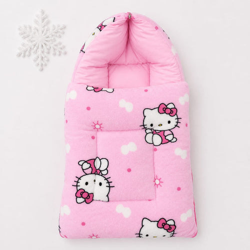 A pink quilted baby footmuff featuring Hello Kitty cartoon prints, shown on a clean white background with a decorative white snowflake in the upper left corner.