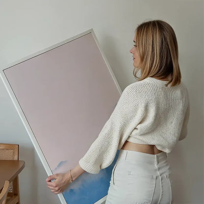 Woman holding a large Forest Pink Blend print with subtle pastel colors in a white frame.
