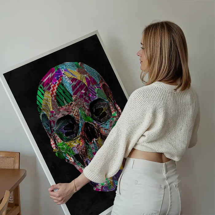 Woman holding a vibrant geometric pattern skull print on black art paper, ready to hang.