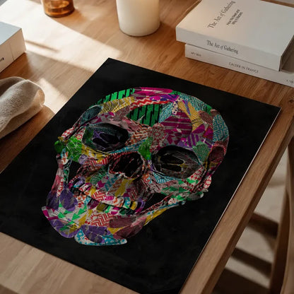 Colorful geometric pattern skull art print on black background, displayed on a wooden table.