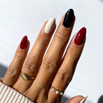 Ghosted black, burgundy and white mix-and-match manicure with gold rings