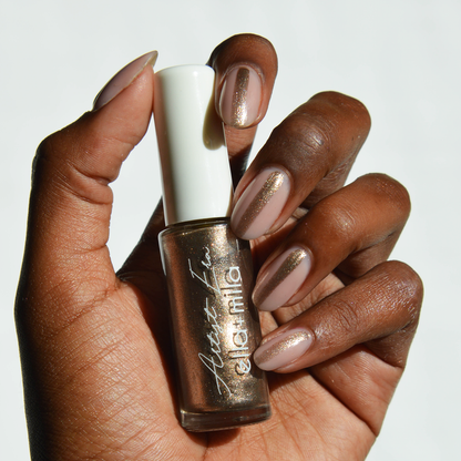 Gladiator Bronze metallic liner on a deep skin tone, hand holding the bottle