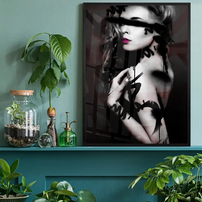 Framed graffiti model print with spray paint marks and vibrant pink lips, hanging on a teal wall.
