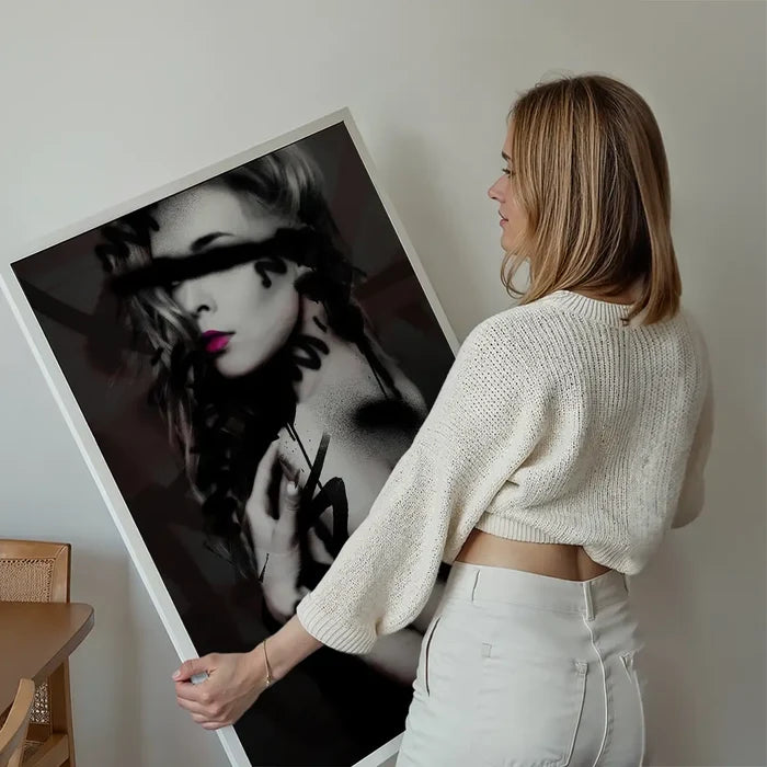 Woman holding a large, unframed "Graffiti Model Print" on thick archival paper, featuring a model with pink lips and black spray paint marks.