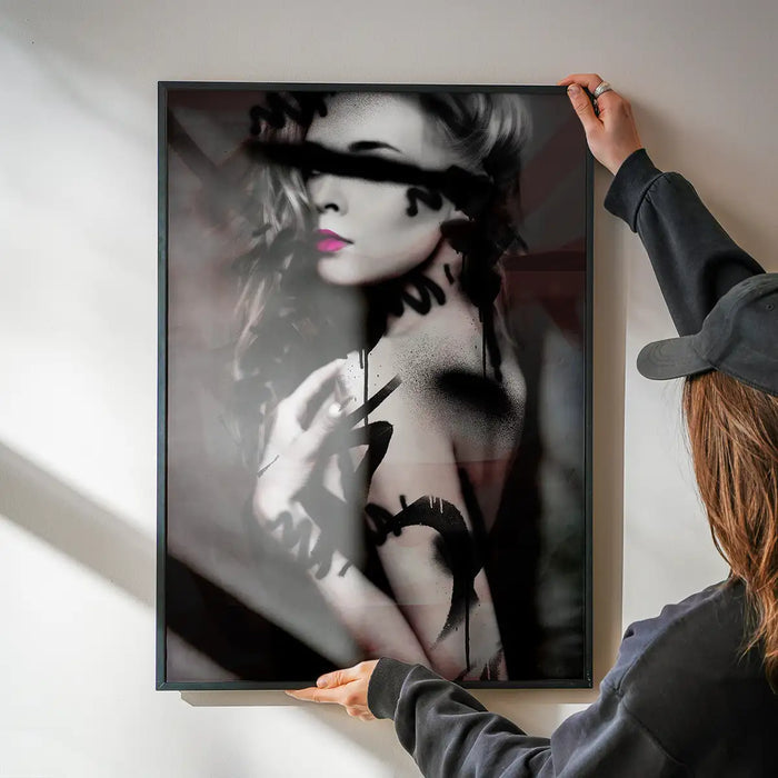 Framed graffiti art print of a model with black spray paint marks and vibrant pink lips.