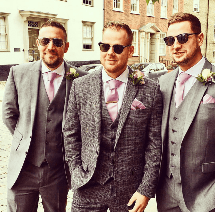 Groomsmen wearing Lavender Frost Pocket Squares and ties with grey suits, showcasing coordinated wedding attire accessories.