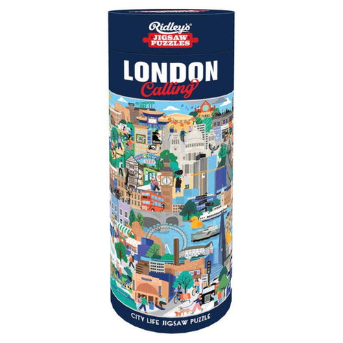 A cylindrical box labeled “London Calling” and featuring colorful illustrations of London city scenes holds the Chronicle Books London Calling City Life 1,000 Piece Jigsaw Puzzle, which captures the vibrant charm of city life.
