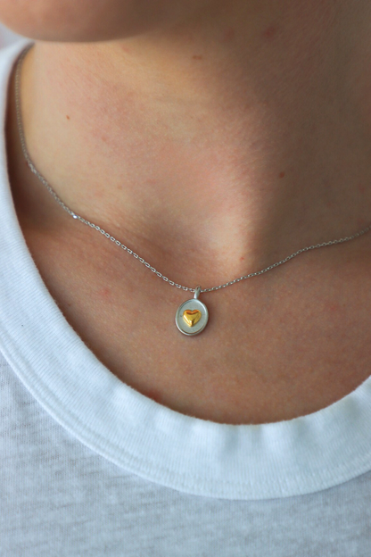 Necklace with a yellow gemstone pendant worn by a person