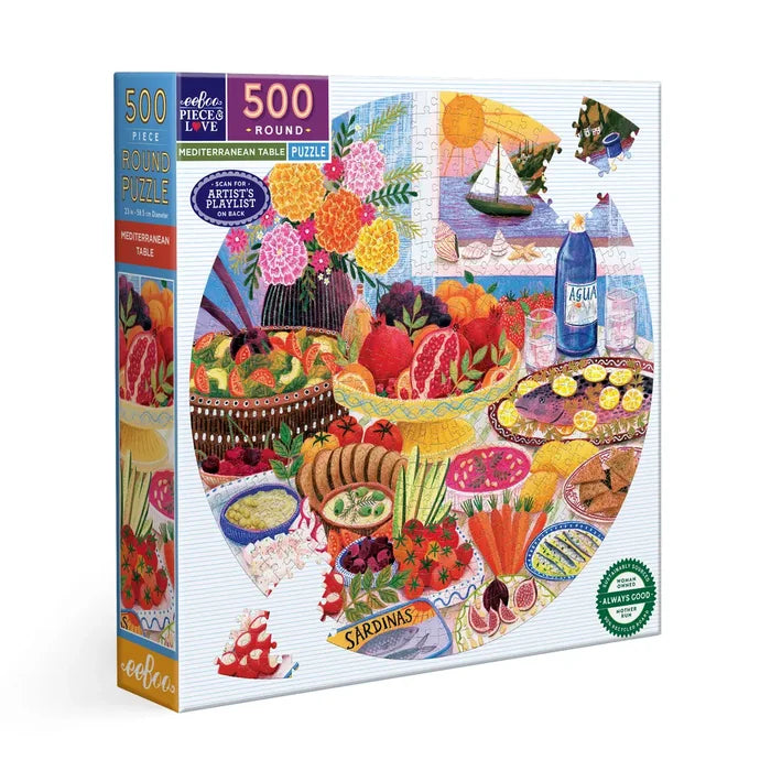 The Mediterranean Table | 500 Piece Jigsaw Puzzle by eeBoo comes in a round box and showcases a vibrant table with food, fruits, flowers, water bottle, and sailboat, all crafted from sustainably sourced materials.