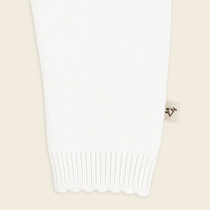 close up of sleeve  from milan dove white delicate pointelle knit baby jumpsuit made with organic cotton