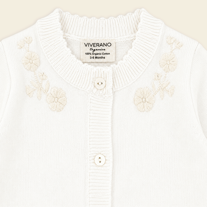 close up of dove white floral embroidered knit baby jumpsuit made with organic cotton