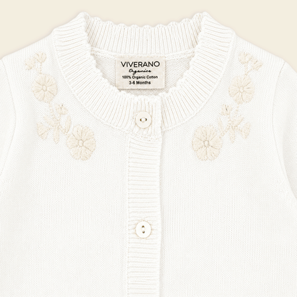 close up of dove white floral embroidered knit baby jumpsuit made with organic cotton