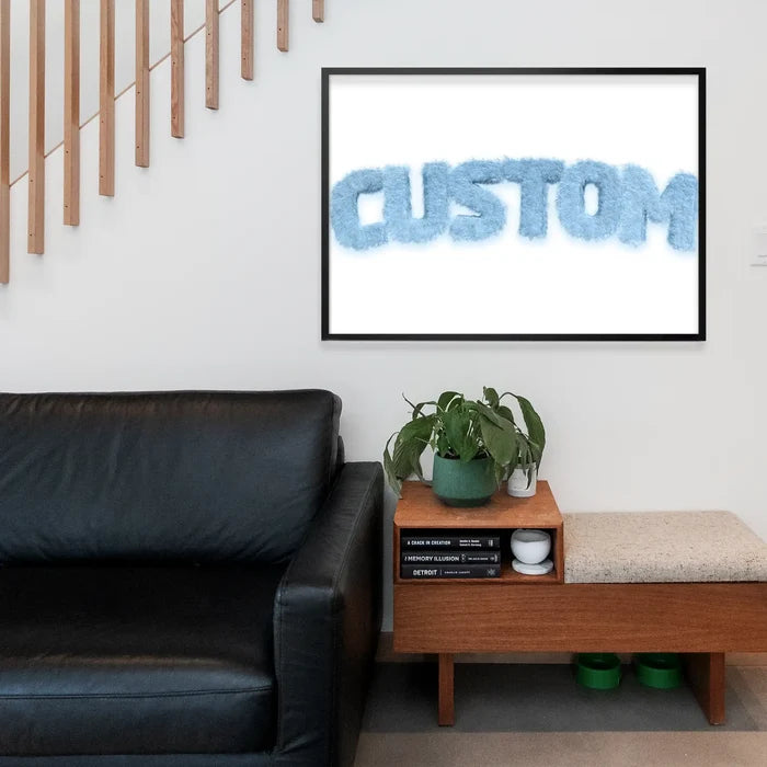 Framed pastel blue fur-style "CUSTOM" name print above a black sofa and wooden bench.