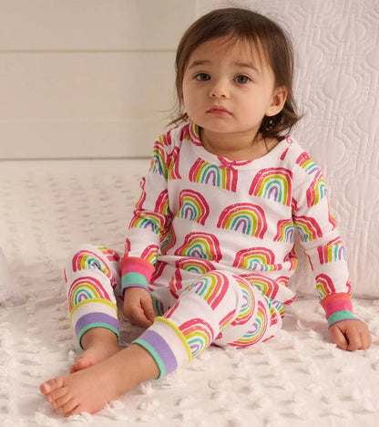 Baby girl wearing Hatley Pretty Rainbows pajamas with colorful print, contrast cuffs, and soft organic cotton.