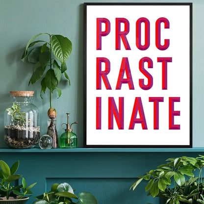 Black-framed "PROCRASTINATE" quote print with bold red and purple lettering on white archival paper, displayed on a teal shelf.
