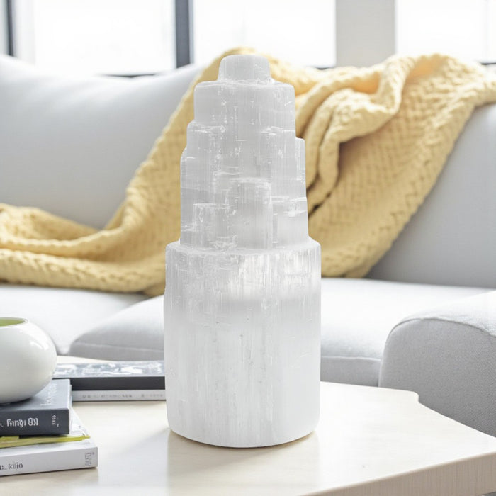 Selenite tower lamp on a table with a blurred background of a living room.