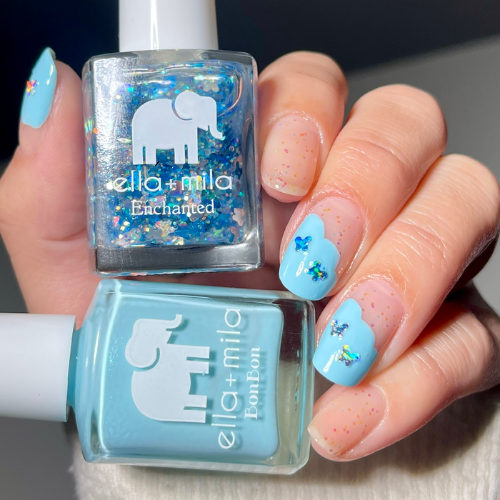 Silver Skyline butterfly glitter over a light blue manicure, holding both bottles