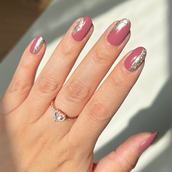 Silverpoint silver glitter liner accents on a mauve pink manicure with a ring in sunlight